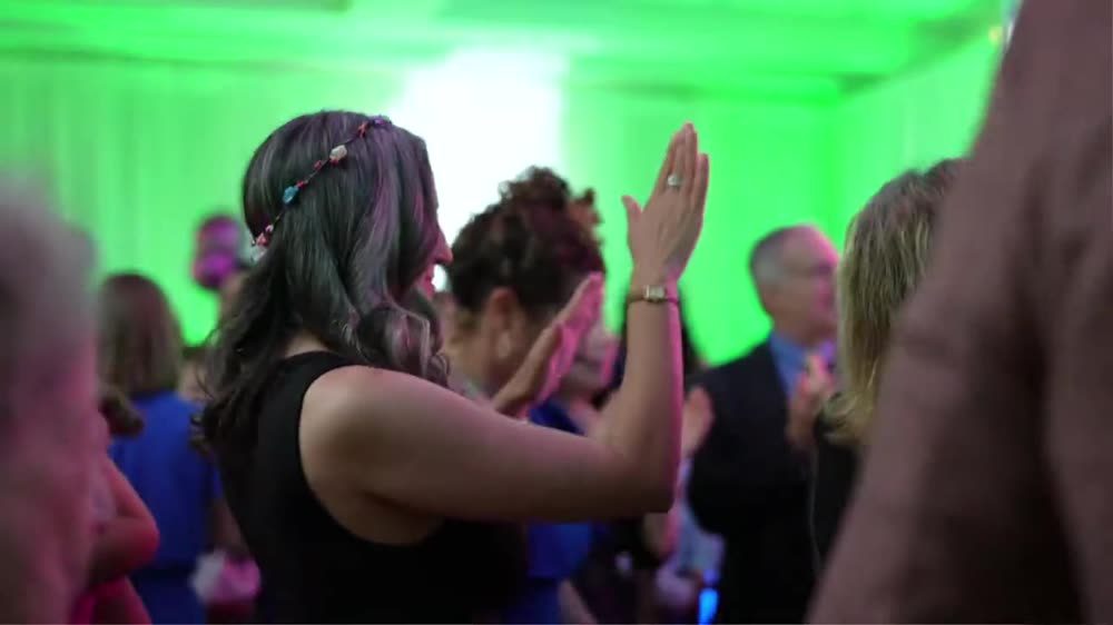 Guests dancing on a green-lit dance floor