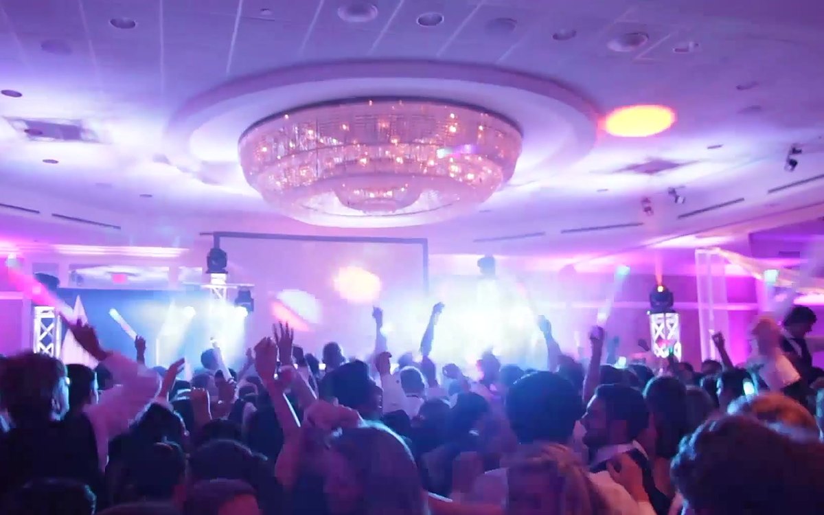 The whole ballroom in purple and pink ATG uplighting with a lit DJ stage at Hilton Charlotte Uptown