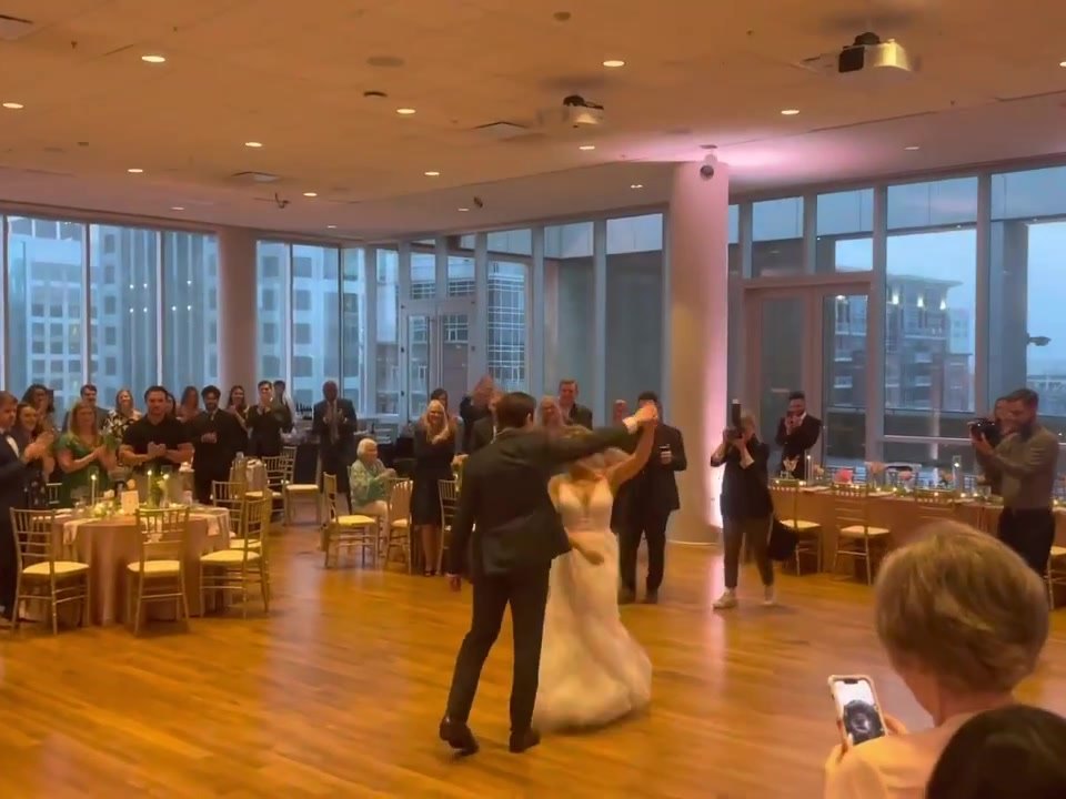 April & Andrew's first dance at the Mint Museum Uptown, with the uptown skyline behind them