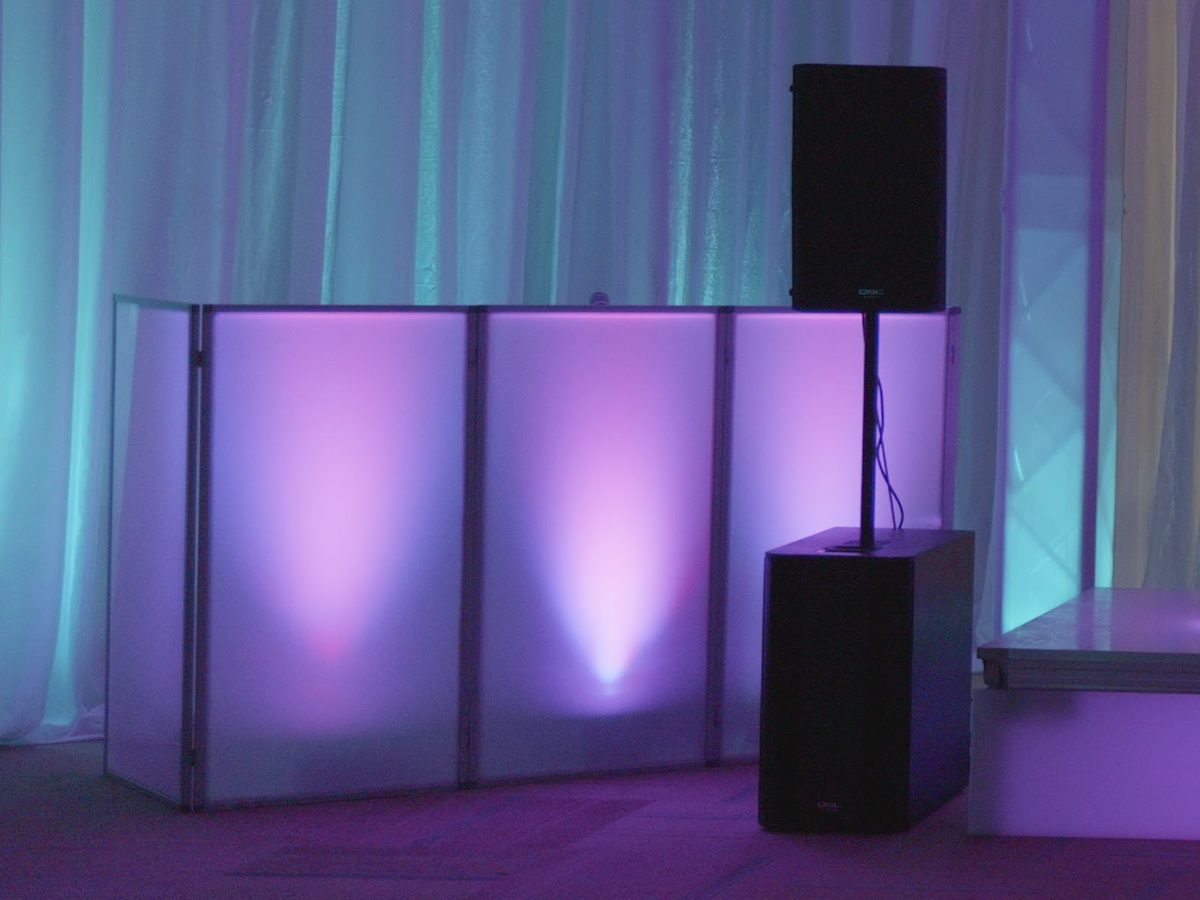White DJ facade glowing purple from the uplights behind it