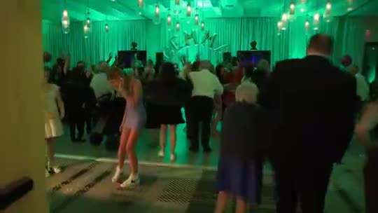 Guests dancing under green and teal lights at Canopy by Hilton Charlotte SouthPark