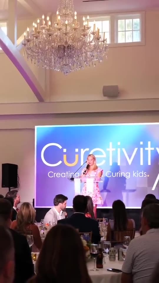 Curetivity presentation on a projection screen in a chandelier ballroom